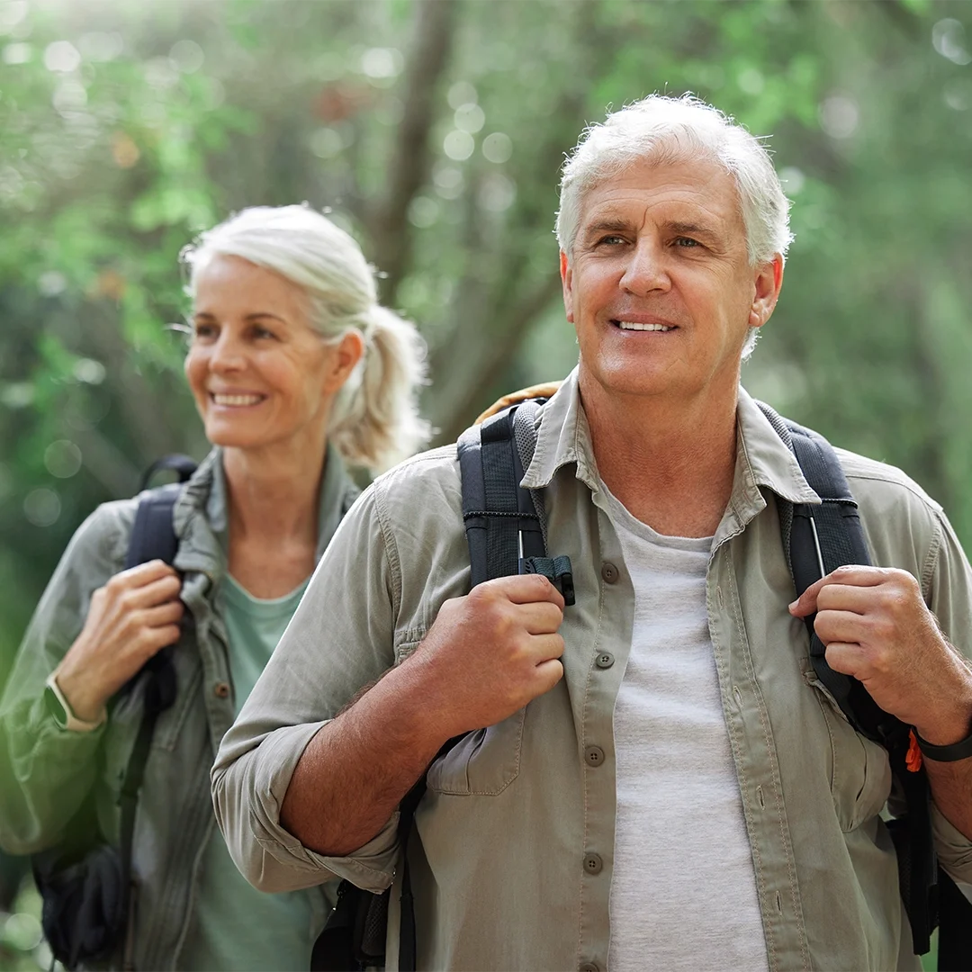 Active seniors smiling with confidence after dental implant restorations