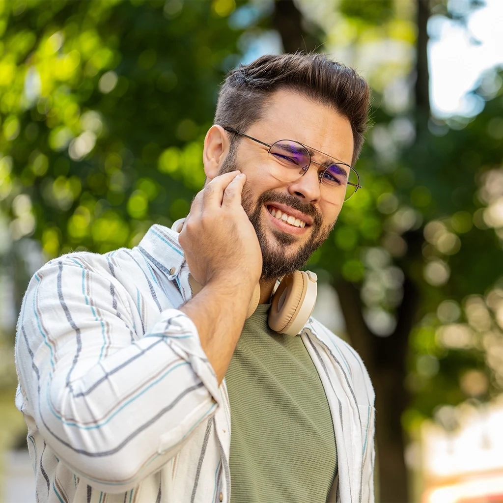 Man holding jaw in pain needing emergency dental care for sudden toothache