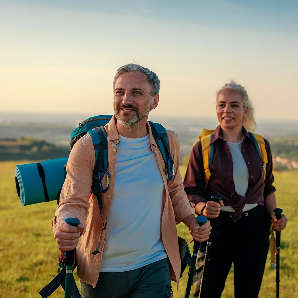 Active couple hiking with confident smiles after dental crowns and bridges treatment