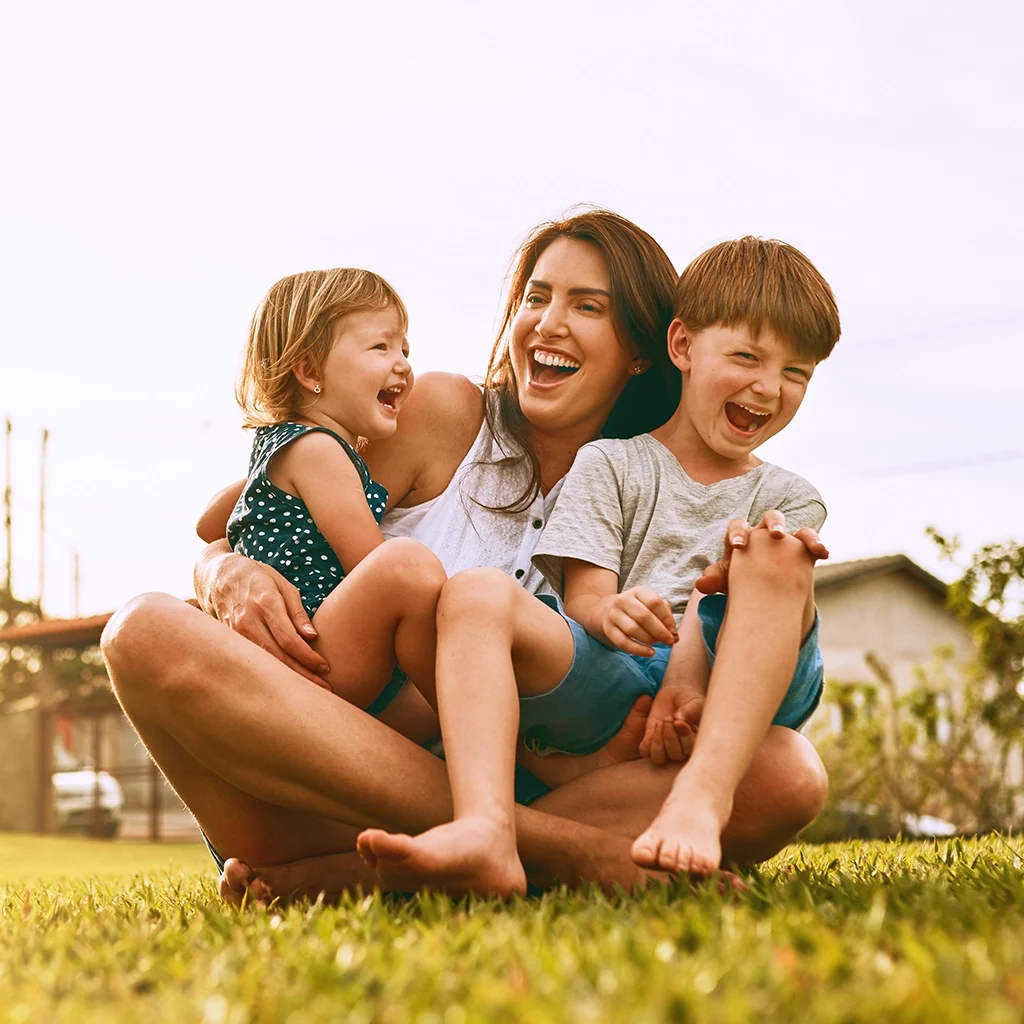 Happy family smiling outdoors after dental exams and cleanings for healthy smiles